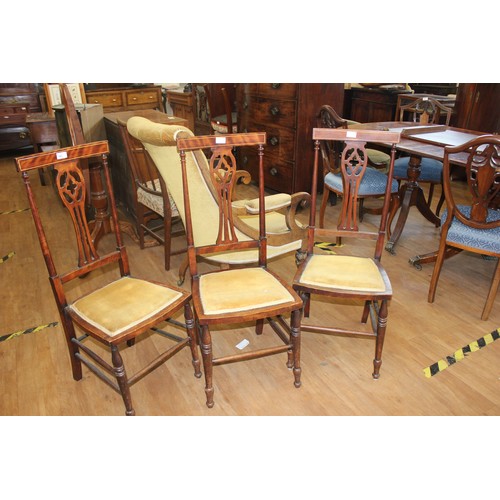 160 - A set of three Edwardian mahogany side chairs with pierced splats, on slender turned legs, united by... 