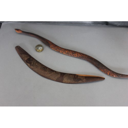 249 - An Australian carved hardwood boomerang, 70cm wide, a further boomerang in shape of snake, 98cm wide... 