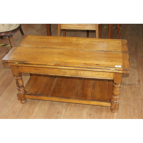 82 - An elm and pine refectory style coffee table, with hinged flaps, 91cm long.