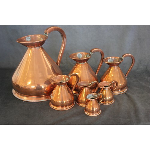 86 - A set of seven copper graduated measuring jugs, from 8th of a gill to 1 gallon (7).