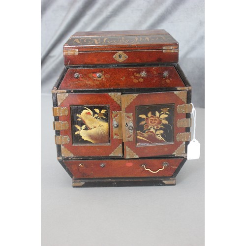 215 - A small lacquered Japanese table cabinet with hinged lid, above a drawer, further drawers below, enc... 