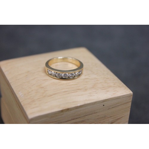 23 - An 18k gold dress ring, set seven slightly graduated diamonds.