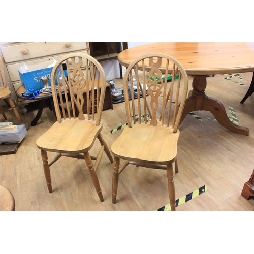 51 - A stripped pine oval dining table on splay legs and four pale beech stick back dining chairs (5).