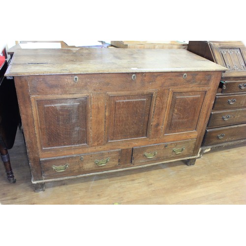 176 - An 18th century oak mule chest, with three lock plates, panelled front, and two drawers, candle box ... 