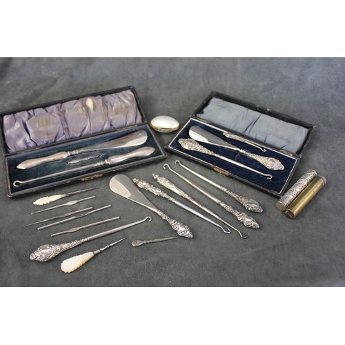 88 - Two silver handled button hook and shoehorn sets, Chester 1912, and Birmingham 1906, in lined cases,... 