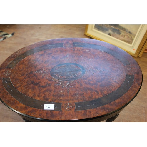 127 - A Victorian ebonised and amboyna oval shaped worktable, on four turned and ringed legs united by cro... 