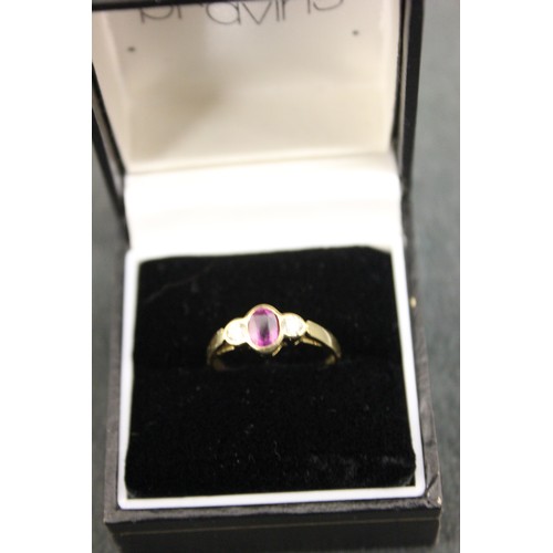 192 - An 18ct gold dress ring, set a central oval cut pink sapphire and two brilliant cut diamonds, in rub... 