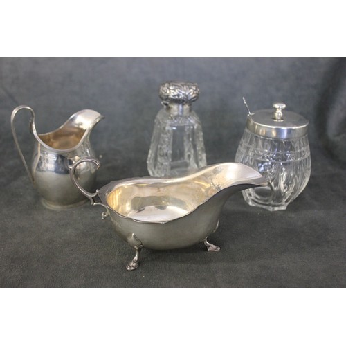 252 - A George V silver cream jug, Chester 1931, a silver sauce boat, Chester 1913, a glass toilet bottle ... 