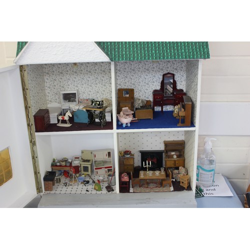 339 - A scale model dolls house, with contents, 54cm wide x 76cm high.