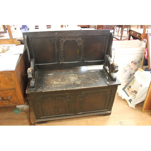 12 - A 20th century carved and stained wood monks bench with panelled top and front, 96cm wide.