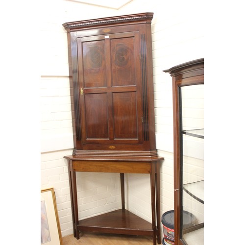 176 - A 19th century inlaid mahogany hanging corner cupboard, enclosed by a panelled door, below a moulded... 