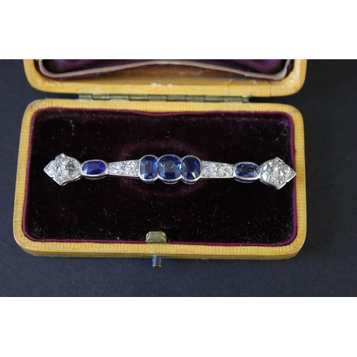 216 - A platinum bar type brooch set twelve diamonds, approx. 0.91 carats, and five sapphires, in lined bo... 