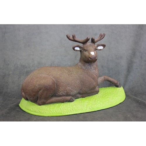 6 - A cast iron and part painted figure of a recumbent stag, approx. 35cm long.