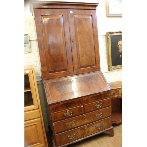 237 - An 18th century walnut veneered bureau cabinet, the upper part enclosed by panelled doors, the slopi... 