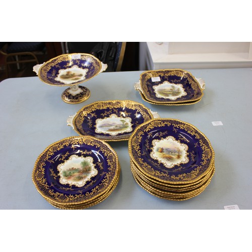 221 - A Coalport part fruit/dessert set, blue and gilt, with painted central panels, comprising:- 