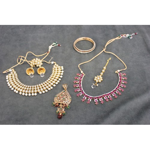 158 - An Indian style necklace, set ruby coloured paste stones, together with a further necklace, a bangle... 