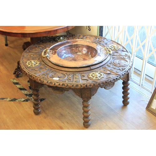 10 - An early 20th century carved and stained wood spitoon table, with brass mounts, and copper dish to c... 