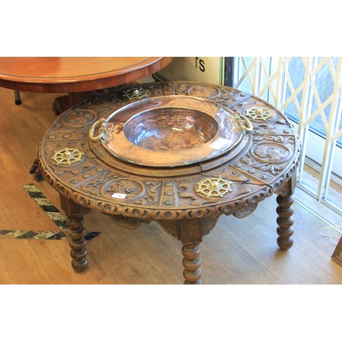 10 - An early 20th century carved and stained wood spitoon table, with brass mounts, and copper dish to c... 