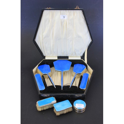 16 - A silver plated and blue enamelled five piece dressing table set, in lined case, together with two u... 