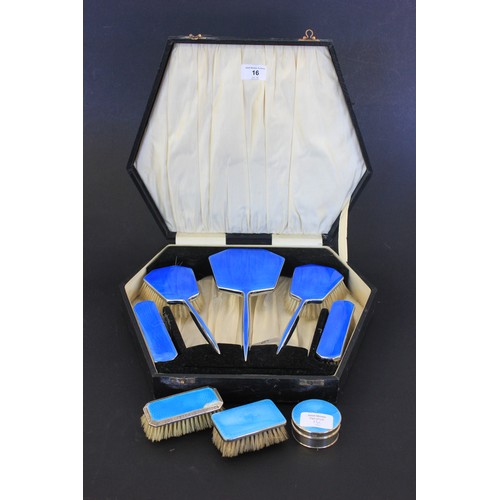 16 - A silver plated and blue enamelled five piece dressing table set, in lined case, together with two u... 