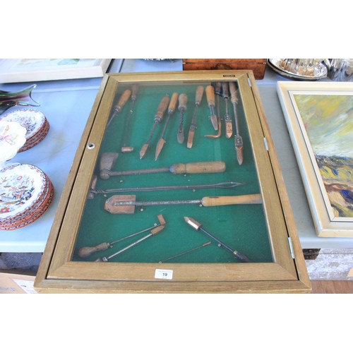 19 - A framed collection of soldering irons, circa 1880-1945, in a display case, 90cm x 60cm.