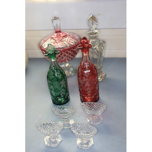 25 - A tapering glass decanter, with decorative cut shoulders, 29cm high, a Bohemian ruby tinted glass de... 