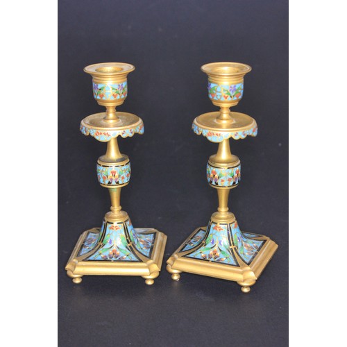 26 - A pair of gilt brass and enamelled candlesticks on square form bases each 18cm high.