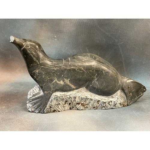 41 - An Inuit soapstone carved figure of a seal, on landscaped base, 48cm long.