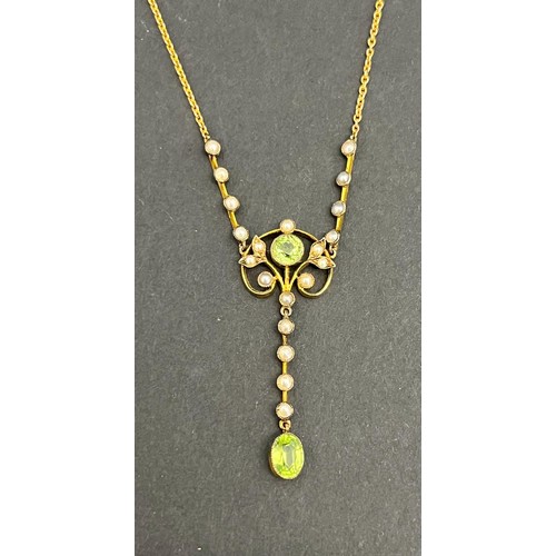 8 - A 9ct gold pendant, set a peridot, a pale blue topaz, and twenty seed pearls, on metal slender link ... 