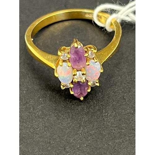 11 - An 18ct gold dress-ring, set four small diamonds, two opals and two pale amethysts.