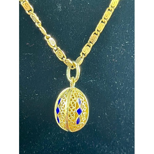 53 - A yellow-metal and blue enamelled oval ball pierced pendant on an 18ct gold link chain approx. 9.3g.