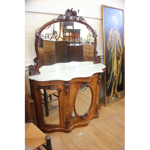 64 - A Victorian walnut credenza with marble top & mirrored back, above three mirrored panel doors, 135cm... 