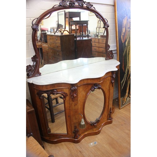 64 - A Victorian walnut credenza with marble top & mirrored back, above three mirrored panel doors, 135cm... 