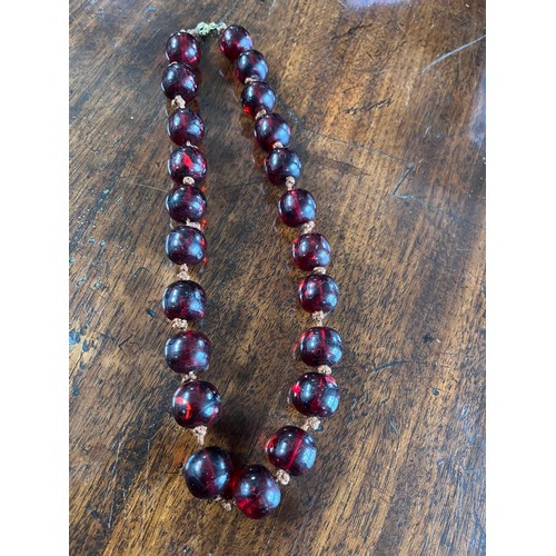 50 - A cherry amber beaded necklace, 48cm long.