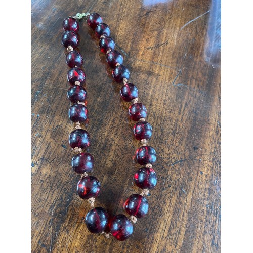 50 - A cherry amber beaded necklace, 48cm long.