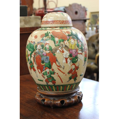 32 - A 20th century Chinese crackle-glazed pottery spice jar and cover, decorated battle scene, on carved... 