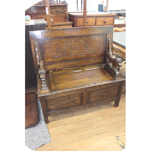 216 - A carved oak monk's bench on block feet, 106cm wide.