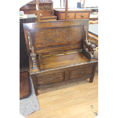 216 - A carved oak monk's bench on block feet, 106cm wide.