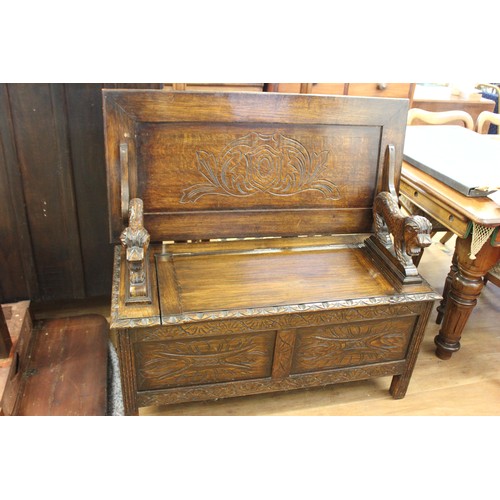 216 - A carved oak monk's bench on block feet, 106cm wide.