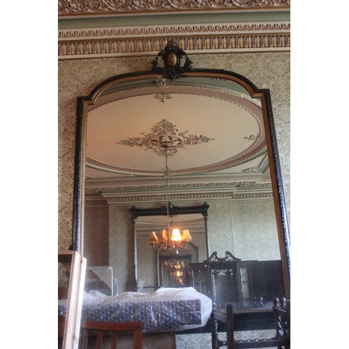 34 - A large Victorian ebonised and gilt arch shaped overmantel mirror with decorative crest, approx. 184... 