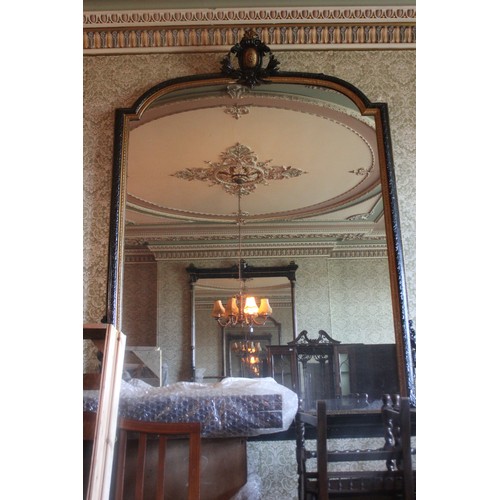 34 - A large Victorian ebonised and gilt arch shaped overmantel mirror with decorative crest, approx. 184... 