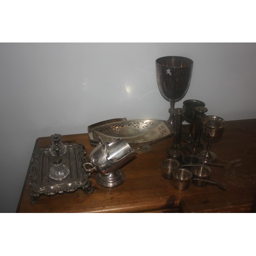 62 - A silver-plated bread basket, an egg cup set, a tray, a cruet set, a bottle stand, a rectangular tra... 