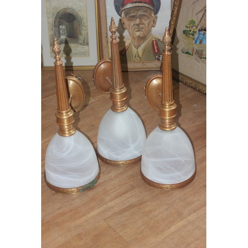 243 - Three gilt-metal wall lights with frosted glass shades, each 65cm high. (3)