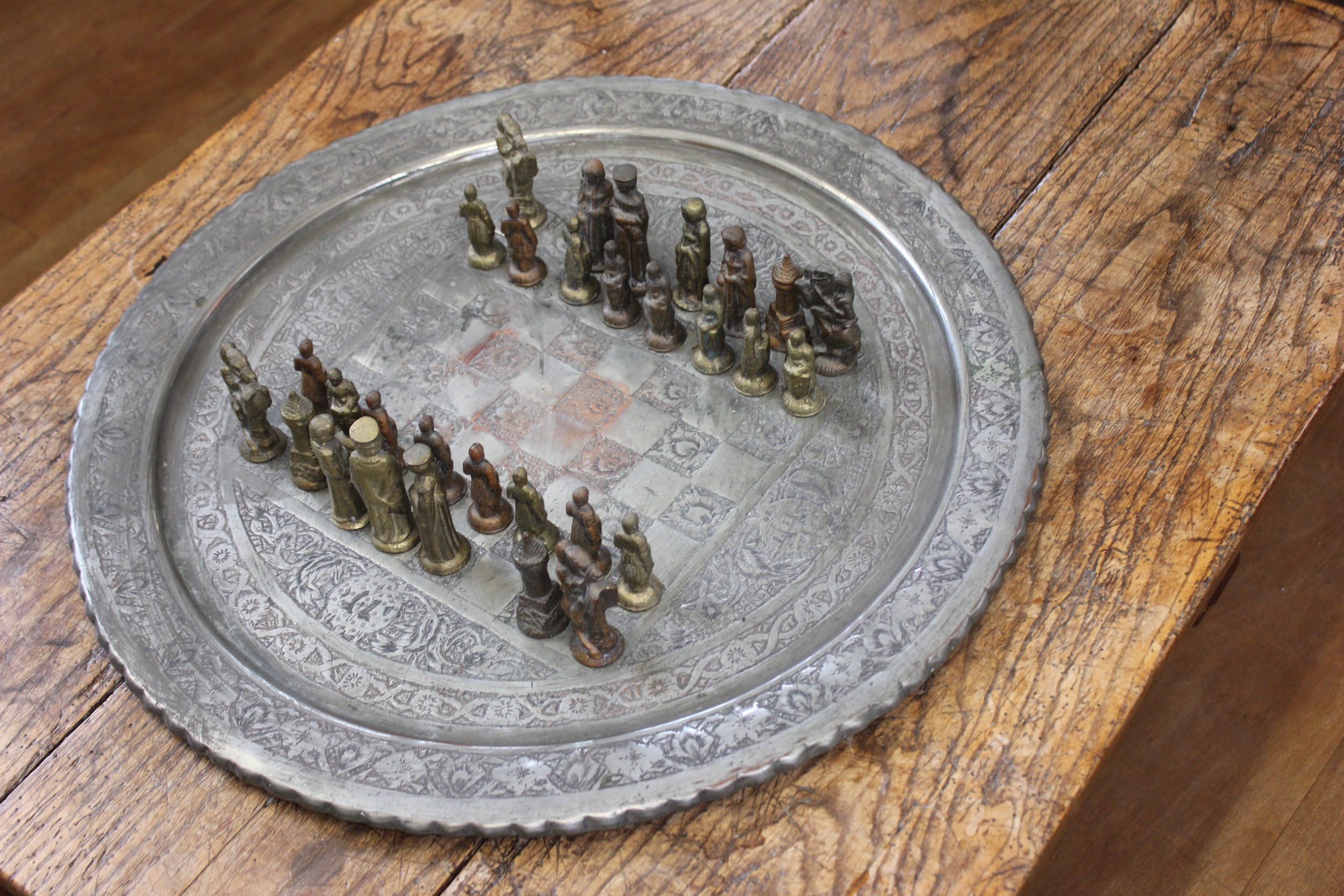 A cast alloy chess set of medieval style, with circular tray-shaped ...