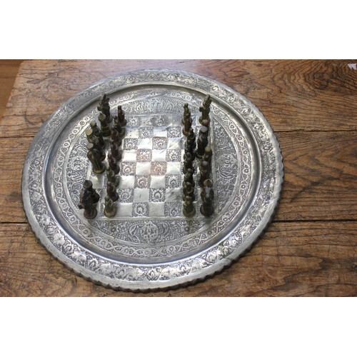 A cast alloy chess set of medieval style, with circular tray-shaped ...