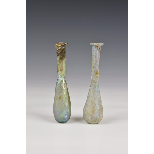 190 - Two Roman iridescent glass unguentariums, 1st-2nd century AD, one in clear glass, with a flat, evert... 