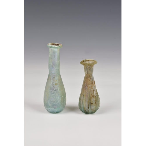 193 - Two small Roman iridescent glass unguentariums, 1st-2nd century AD, both in very pale blue glass, on... 