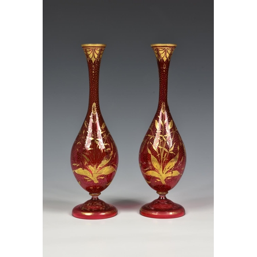 84 - A pair of late 19th century Bohemian cranberry glass bottle vases, decorated with delicate hand gild... 