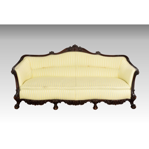 556 - A late Victorian carved mahogany showframe settee, the serpentine back with foliate, cabochon and sc... 