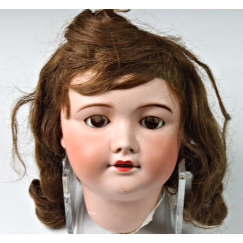 28 - A large German bisque head doll, stamped '12', with weighted dark brown eyes, real hair lashes and h... 